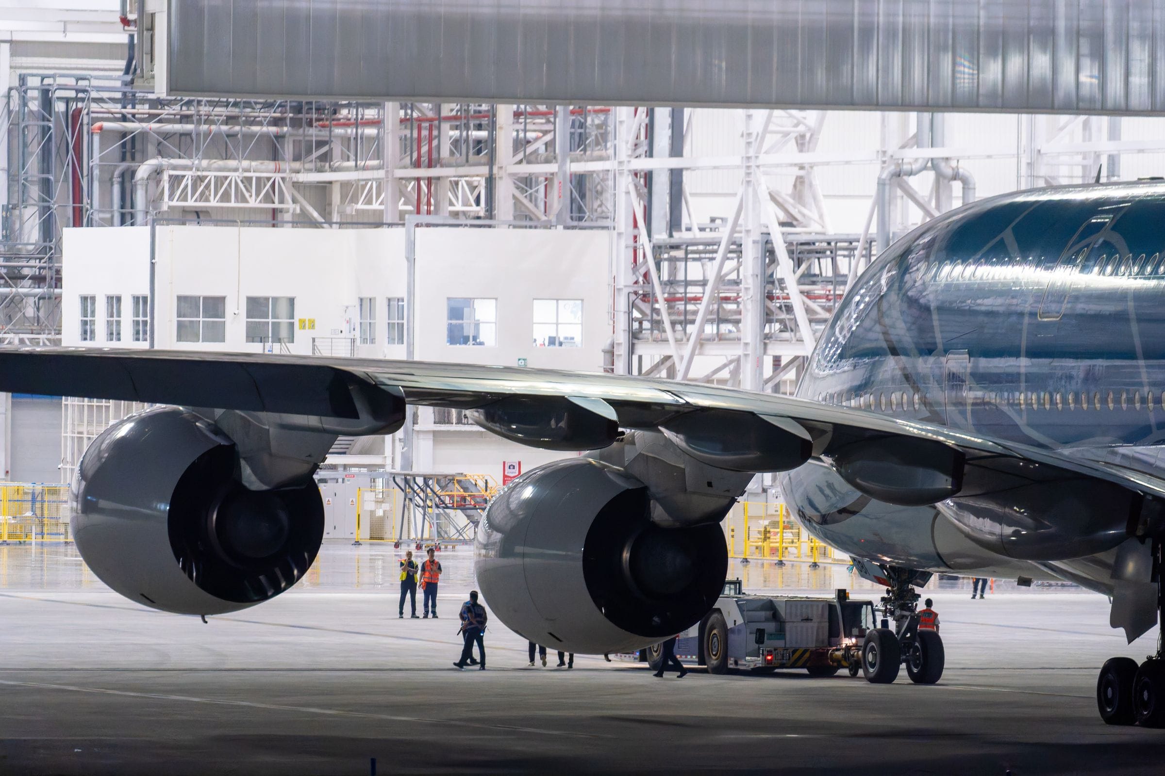 Wide-body airliner and ground crew in a maintenance hangar